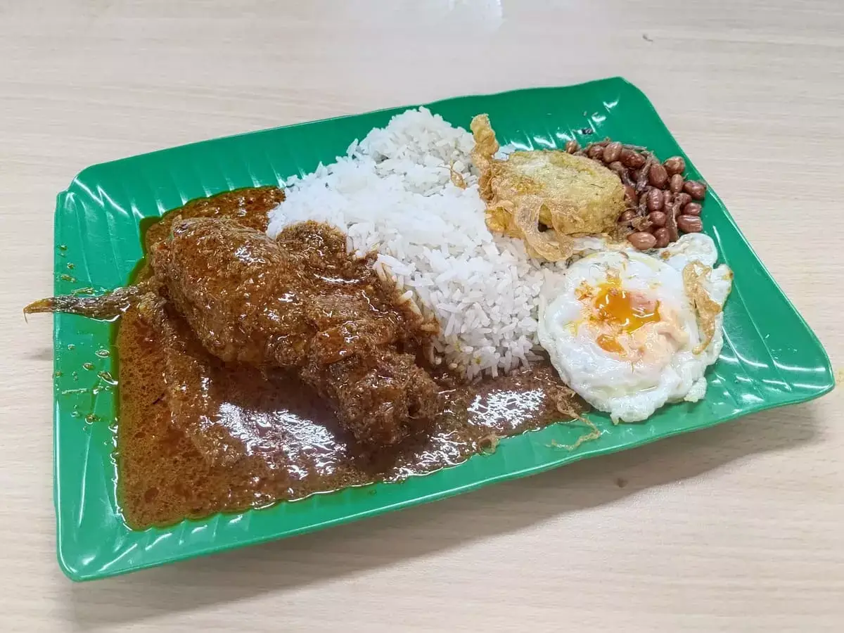 Indonesian Cuisine Nasi Lemak: Rice with Chicken Rendang, Fried Egg, Begedil, Ikan Bilis Peanuts